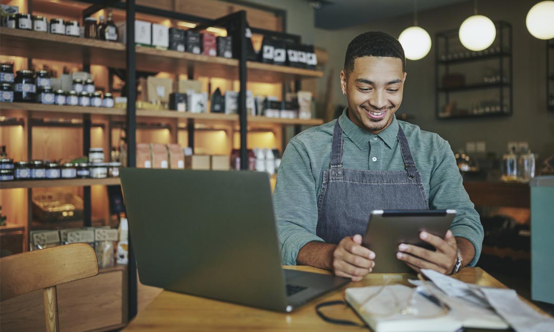 business owner sitting in his shop looking at a computer