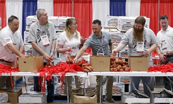 Volunteers pack potatoes during the Uniting to Combat Hunger event at the 123rd VFW National Convention in Kansas City